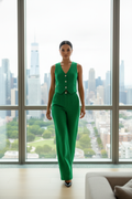Woman in a green outfit standing in front of a cityscape view