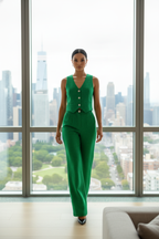 Woman in a green outfit standing in front of a cityscape view