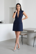 Woman in a navy blue dress standing in a modern interior setting